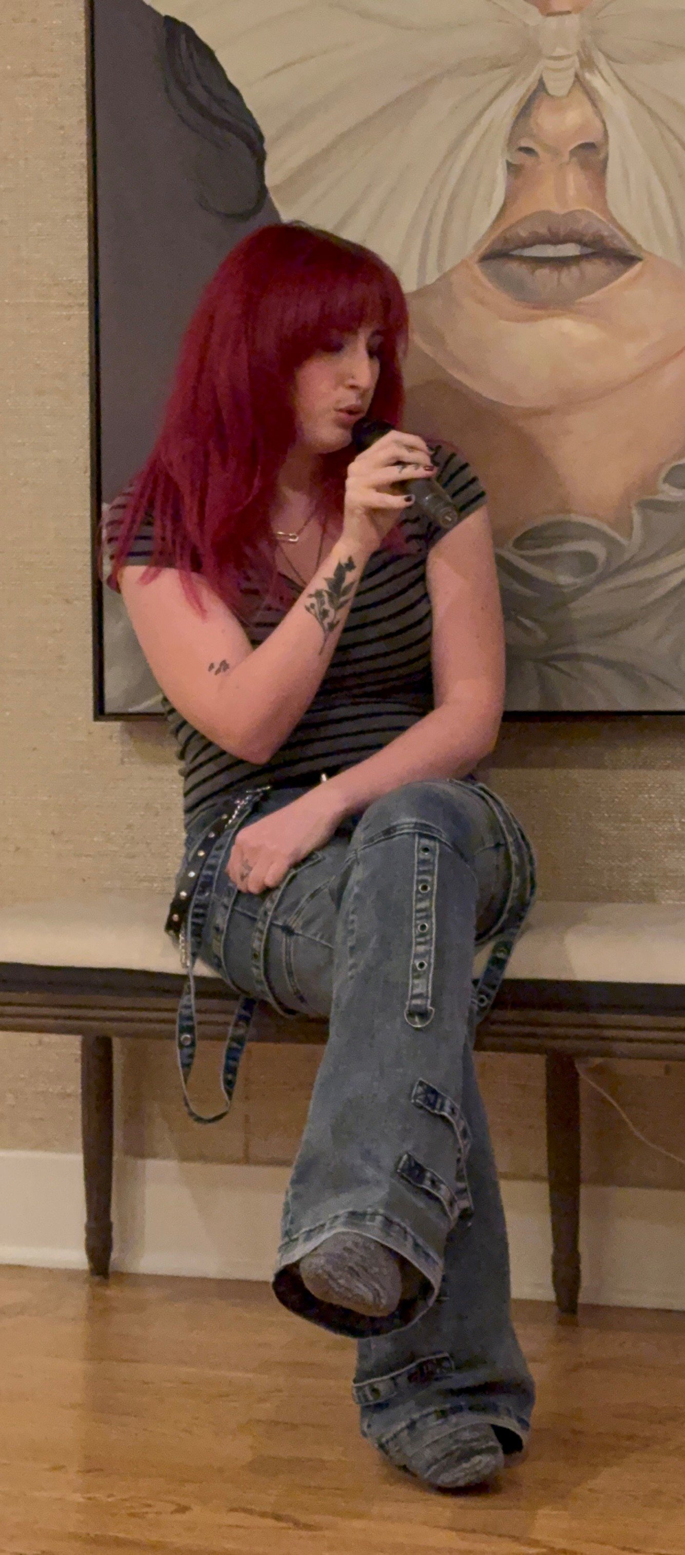 Rachel Silvers performing seated with a handheld microphone