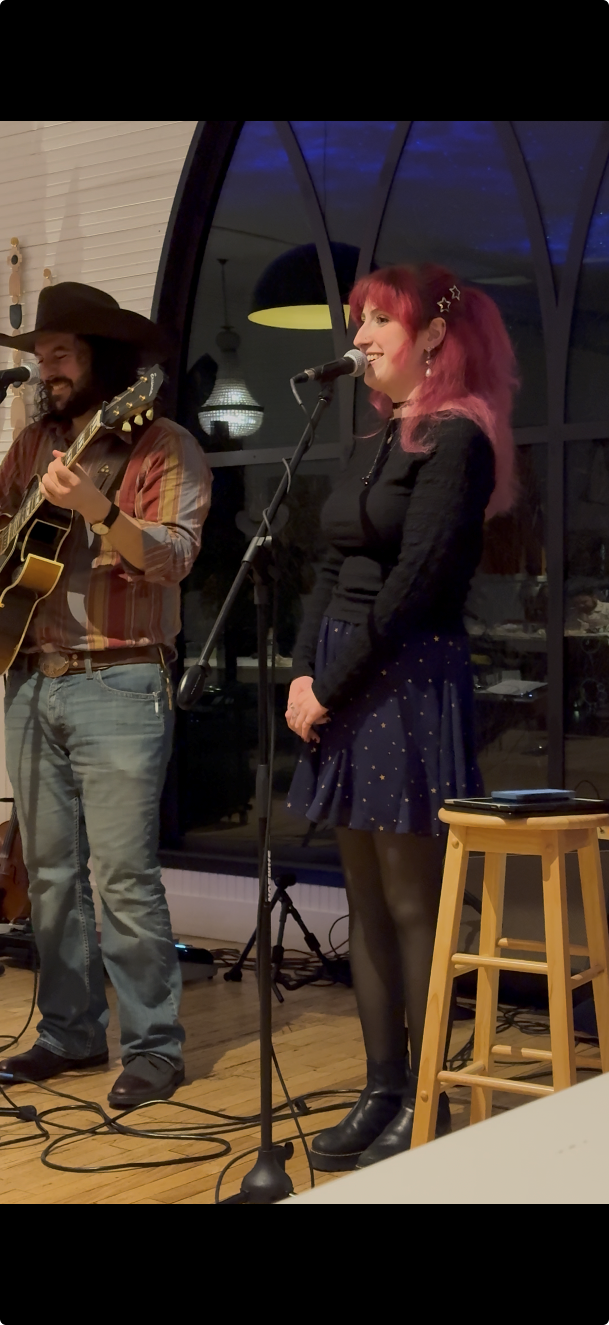 Rachel Silvers singing on stage alongside a guitarist