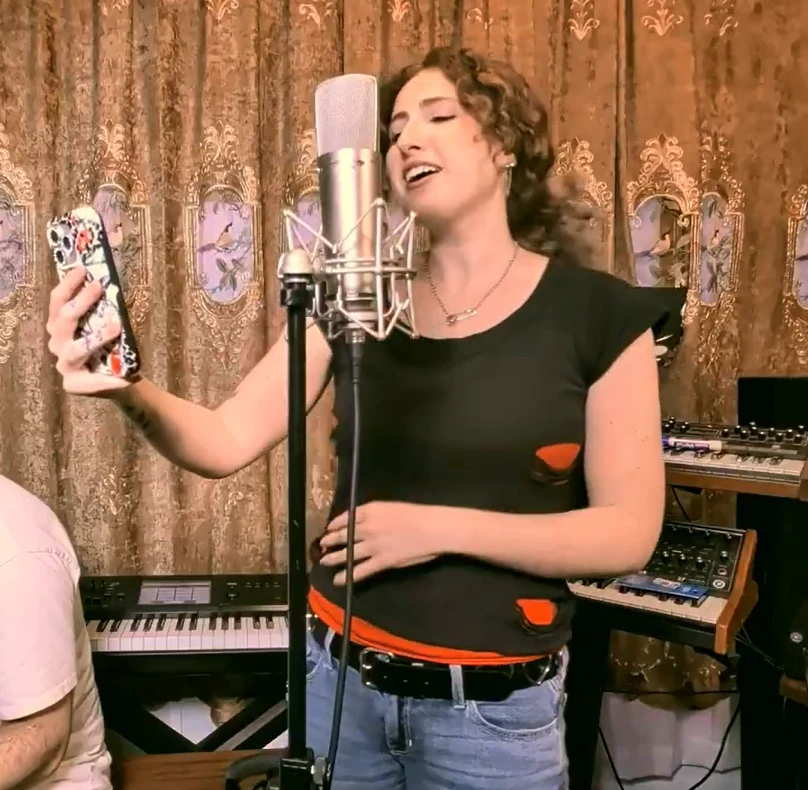 Rachel Silvers singing into a studio microphone